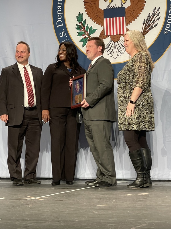 Don Burd, Jessica Vollbrecht, and Dr. Webb receive the National Blue Ribbon Award given to EAHS on stage